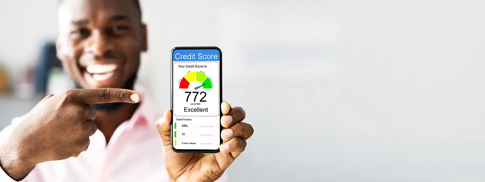 Man smiling and showing his excellent credit score on a phone screen.