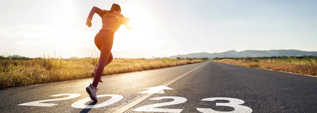 Woman running on an empty road on a summer day, symbolizing the journey of rebuilding credit and regaining financial health.